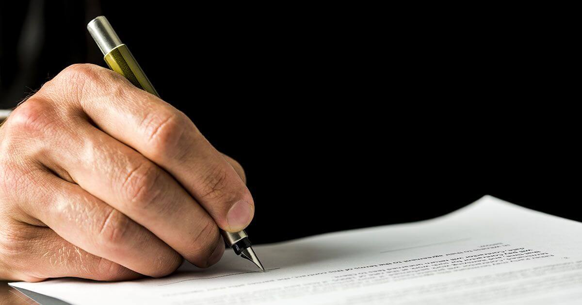 Man writing on a paper with a pen