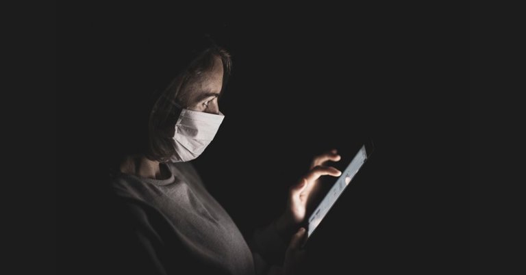 Woman wearing a mask while browsing her phone