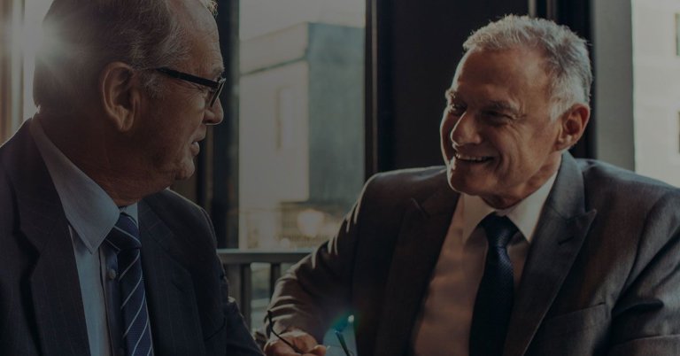 An elderly man discussing with his lawyer regarding retirement accounts