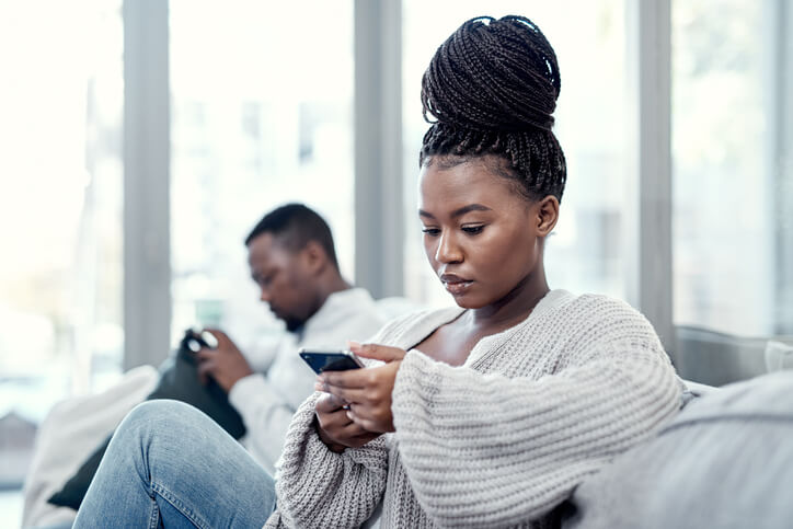 Husband and wife ignoring eachother on their phones