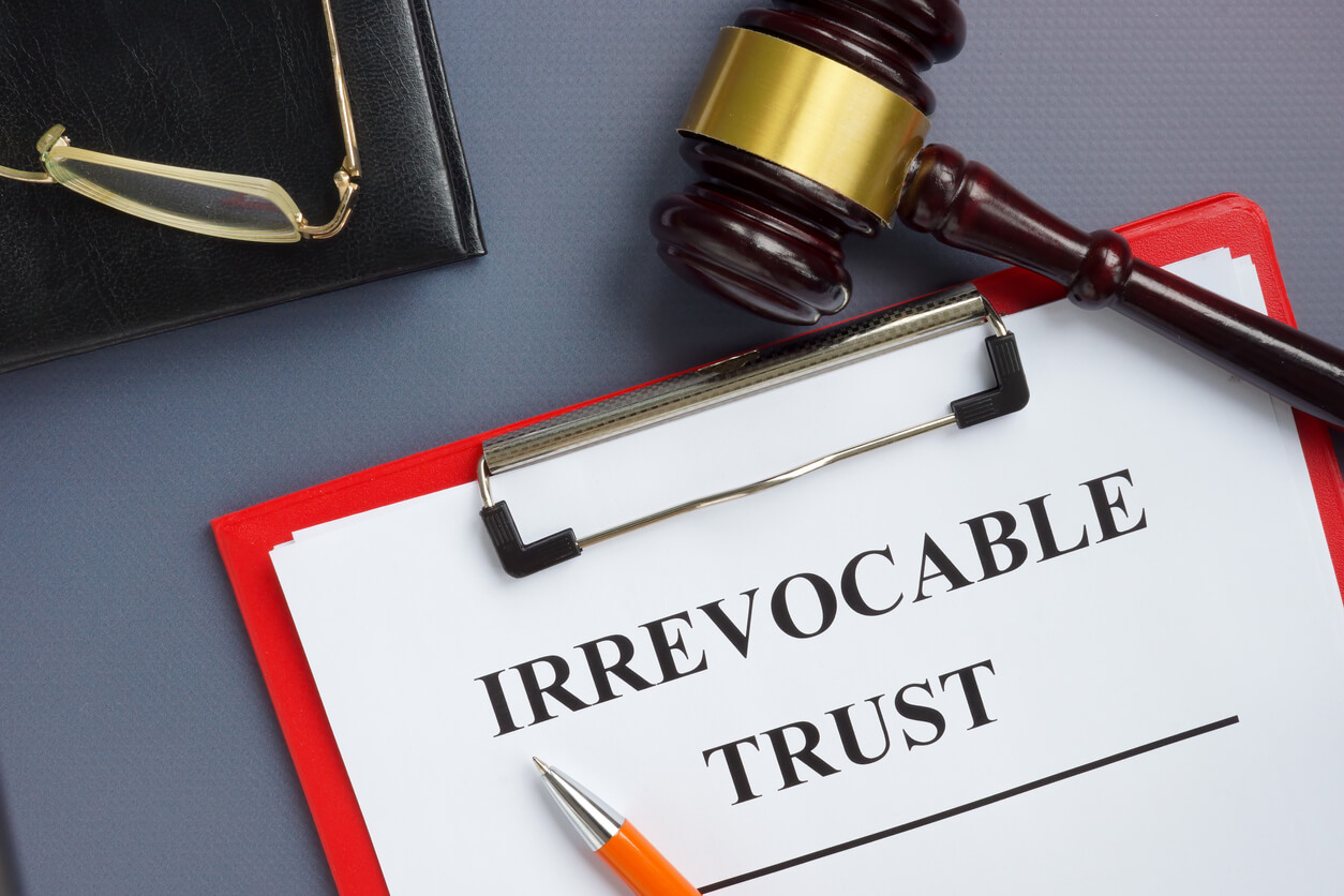 Irrevocable trust document on the clipboard and gavel.