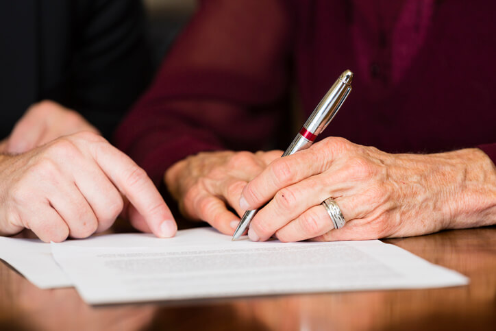 Older woman signing estate planning documents