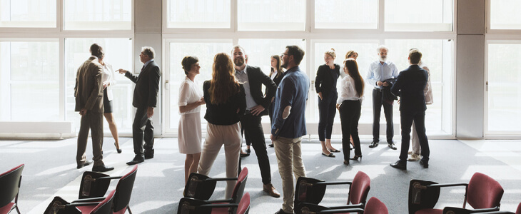 Employees from two companies conversating after a merger