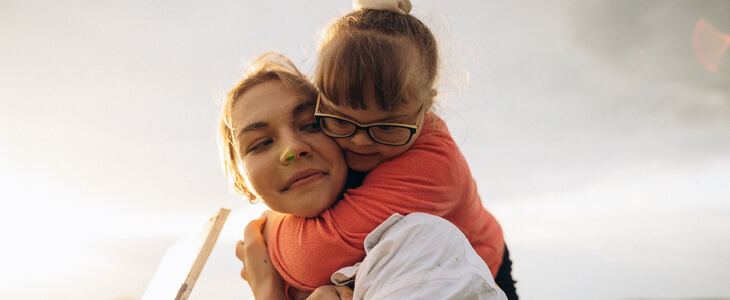 Young mother hugging her daughter, who is special needs.